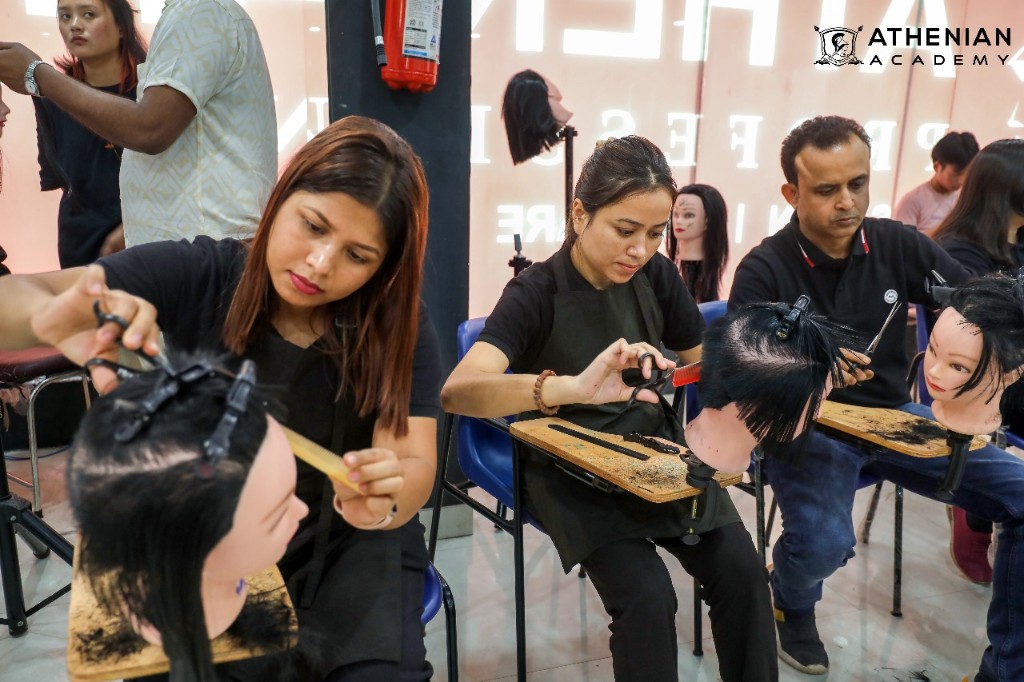 Students practicing precision haircutting on mannequins at Athenian Beauty Academy