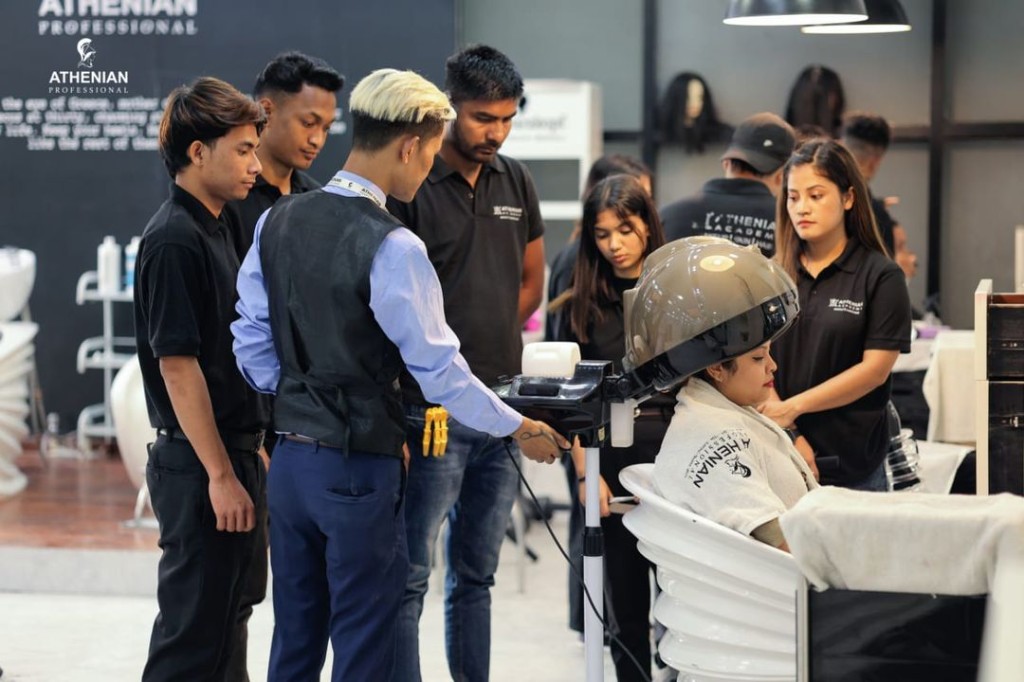 Athenian Academy instructor demonstrating professional hair steamer technique with students